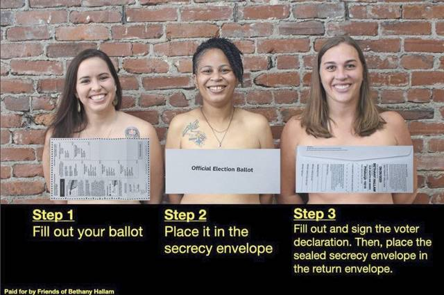Three topless women have signs
in front of their breasts that remind people how to fill out their ballots properly