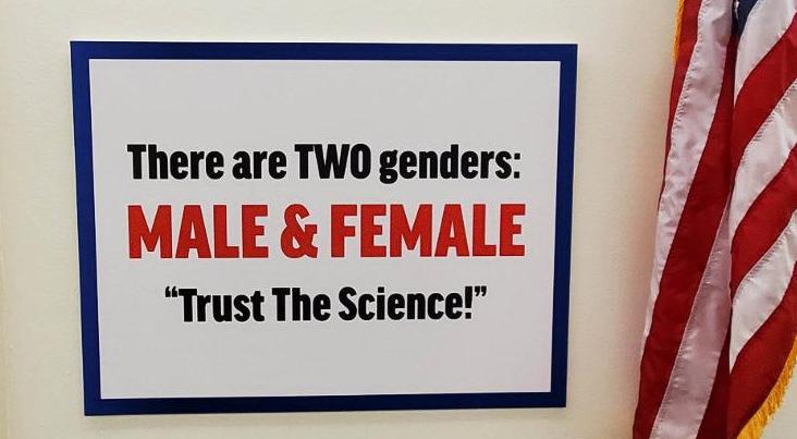 The sign says 'There are two genders,
male and female, trust the science'