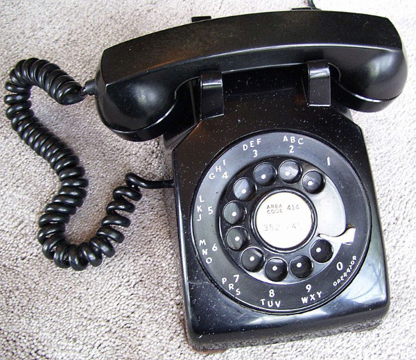 A black phone with 
standard handset and rotary dial