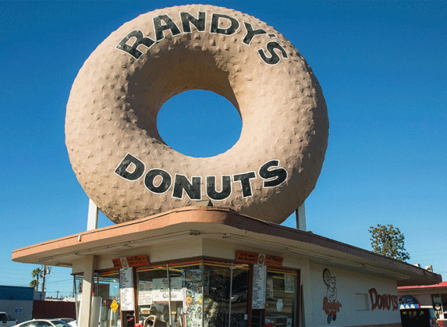 A one-story, plain, basically square-shaped,
fairly small donut shop, but with a giant donut on top--at least 50 feet tall--that says 'Randy's Donuts.'