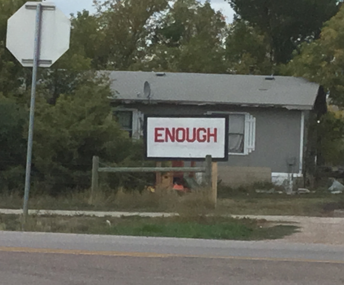 The sign says 'ENOUGH' in capital letters.