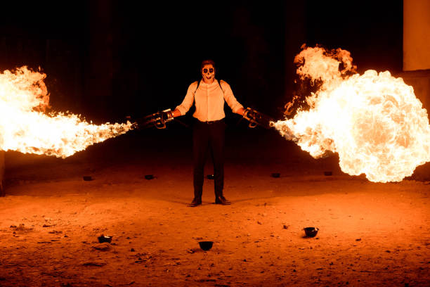 A man in a skull mask fires vast plumes of fire out of both of his hands