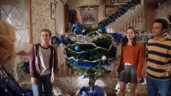 The three kids stand around
a spherical tree, decorated with Hanukkah ornaments and colors. It just looks like a ball-shaped Christmas tree, though.