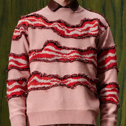 Pink background, with three ribbon-shaped lines running across it, the ribbons are the color of bacon, but look like what would happen if you took a scalpel to someone