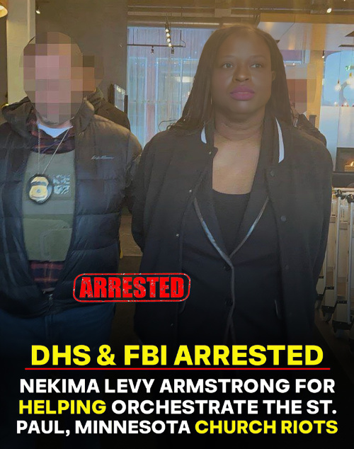 Levy Armstrong
is escorted by an officer of some sort whose face is blurred out. Her face is emotionless.