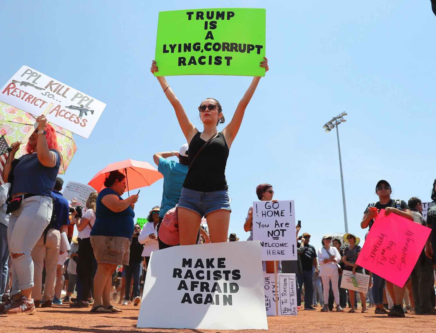 Protester holds sign that 
describes Trump as a lying, corrupt racist.