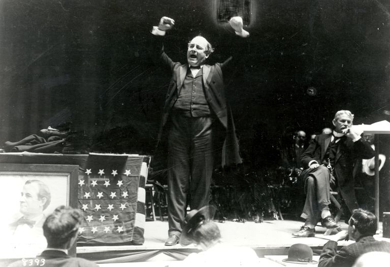 William Jennings Bryan speaks to a crowd,
his arms raised above his head for emphasis