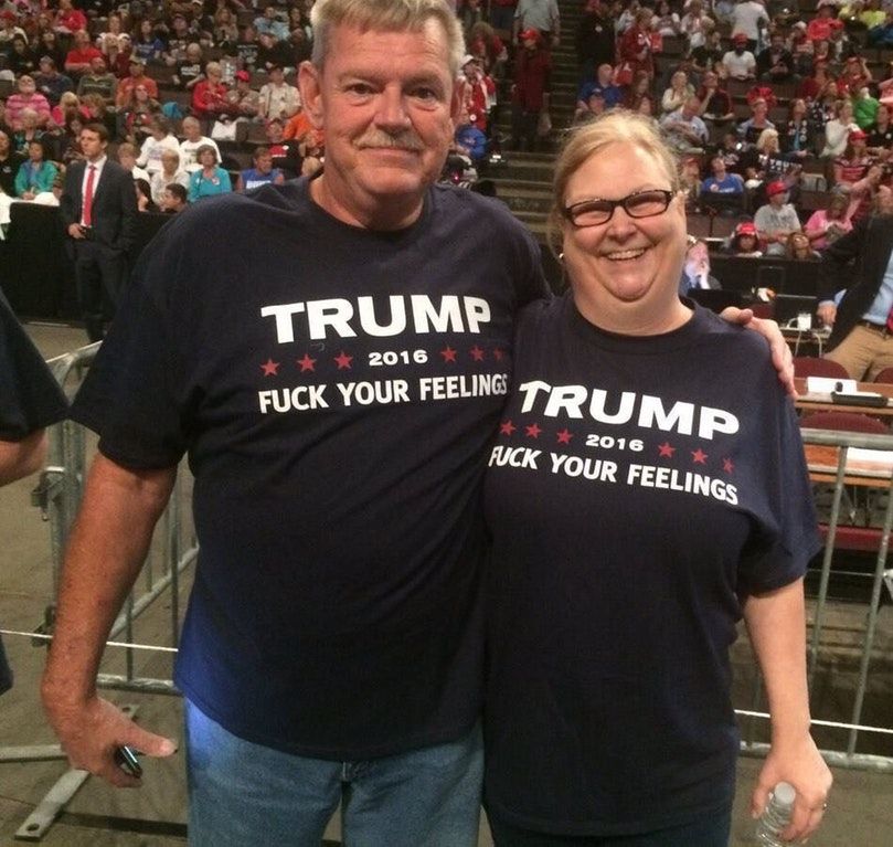 Two white people, a man and a woman
who appear to be about 60, wear shirts that say 'Fuck your Feelings' Trump 2016