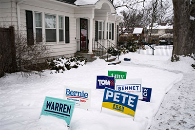 House where caucus will take place with yard signs in front