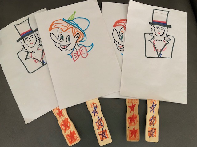 four paddle-type signs, two with drawings of Abe Lincoln and two with Pinocchio