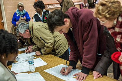 People filling in paper forms