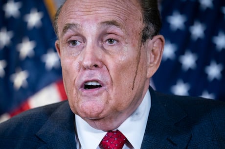 Streaks of black run down Giuliani's
face at the temples