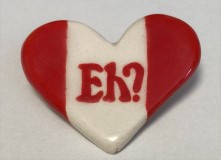 A heart-shaped cloisonne pin with 'eh' on it