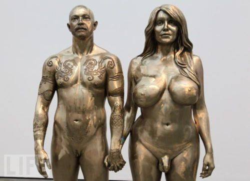 A person who is very male from the waist up
but not from the waist down, and a person who is very female from the waist up, but not from the waist down, are standing next
to each other, spray-painted in gold paint.