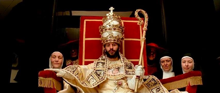 Ringo Starr, dressed as the pope, and sitting
on a chair that looks like the papal throne.