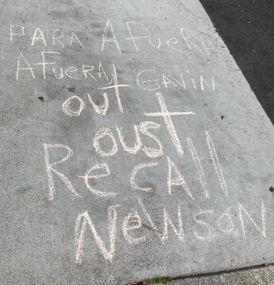 Someone has used chalk and written
on a sidewalk 'Para afuera afuera Gavin out oust recall Newson.' And note that this is a completely accurate transcription.