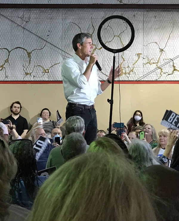 O'Rourke stands among a large crowd, holding a microphone