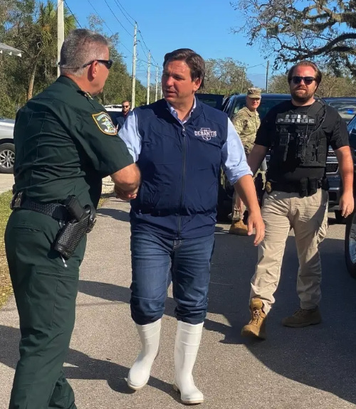 Ron DeSantis in godawful
white boots that cover his blue jeans up to the knee
