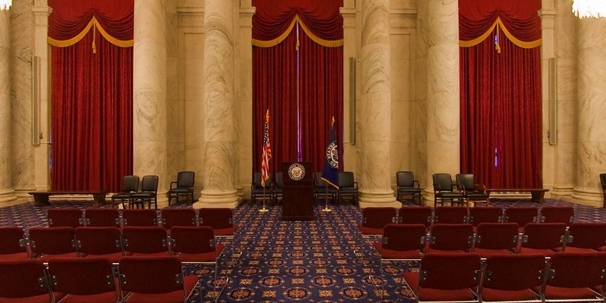 It's a large room, with marble pillars,
tall maroon curtains, blue and red and yellow carpet, and rows of red chairs arranged like a movie theater. There are chairs and a 
podium at the front.