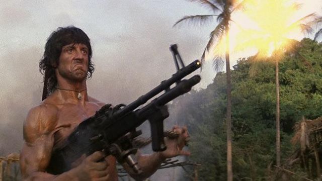 John Rambo, shirtless, firing a flamethrower