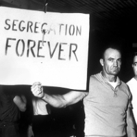 A protester holds a sign that says 'Segregation Forever'