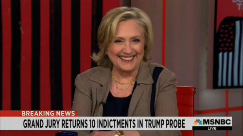 Hillary Clinton MSNBC, smiling, at a 
time that the chyron happens to say 'Grand Jury Returns 10 Indictments in Trump Probe