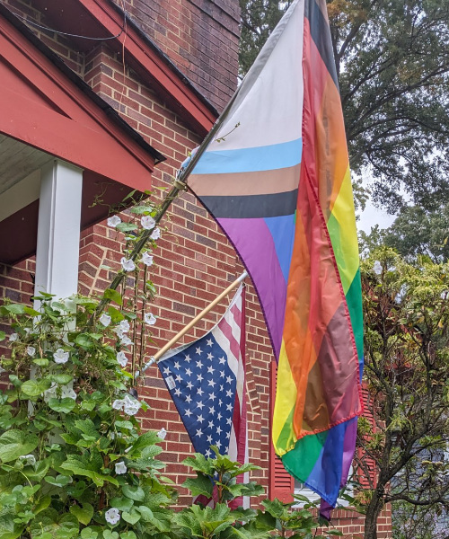 A rainbow flag and an upside-down U.S. flag
