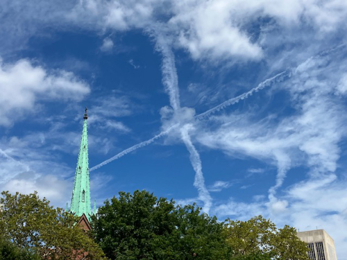 A pair of skywriting trails are crossed, forming a giant 'X' in the sky.