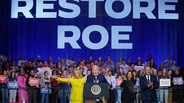 Biden at a Rally at George Mason University emphasizing Restoring Roe,
with 'RESTORE ROE' in giant letters projected onto the backdrop