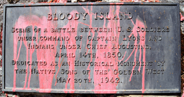 The plaque commemorates the
1850 massacre at Bloody Island, and has been covered in red paint