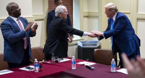 Trump shakes hands with Mitch
McConnell, who is standing about as far away as possible while still making contact