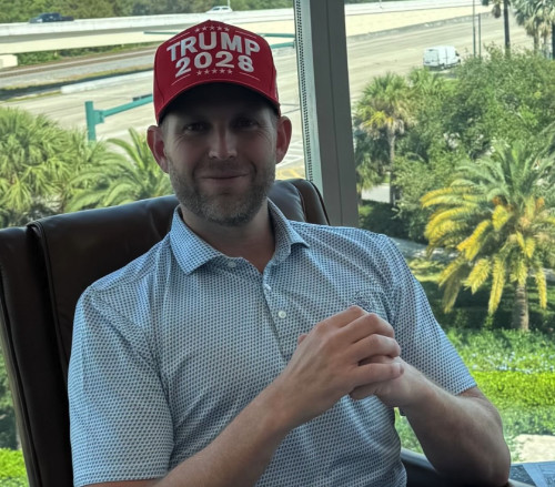 Eric Trump wearing a red
baseball cap with TRUMP 2028 in very large letters that also appear to be puffy