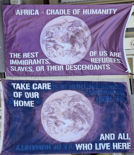 Picture of Earth on both
sides; one side says 'AFRICA - CRADLE OF HUMANITY THE REST OF US ARE IMMIGRANTS, REFUGEES SLAVES. OR THEIR DESCENDANTS'
and the other says 'TAKE CARE OF OUR HOME AND ALL WHO LIVE HERE'