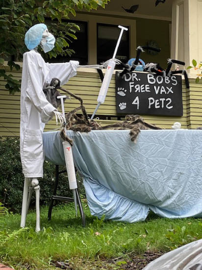 A skeleton is dressed like a
surgeon, and is injecting a spider with a giant needle, next to the sign 'UR. BOB's FREE VAX 4 PETS