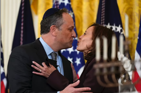 A familiar-looking man with a yarmulke and a familiar-looking woman kiss