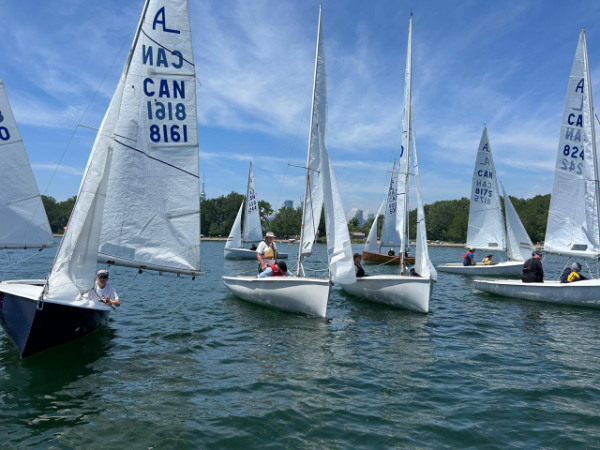 A group of small sailboats with two-person crews