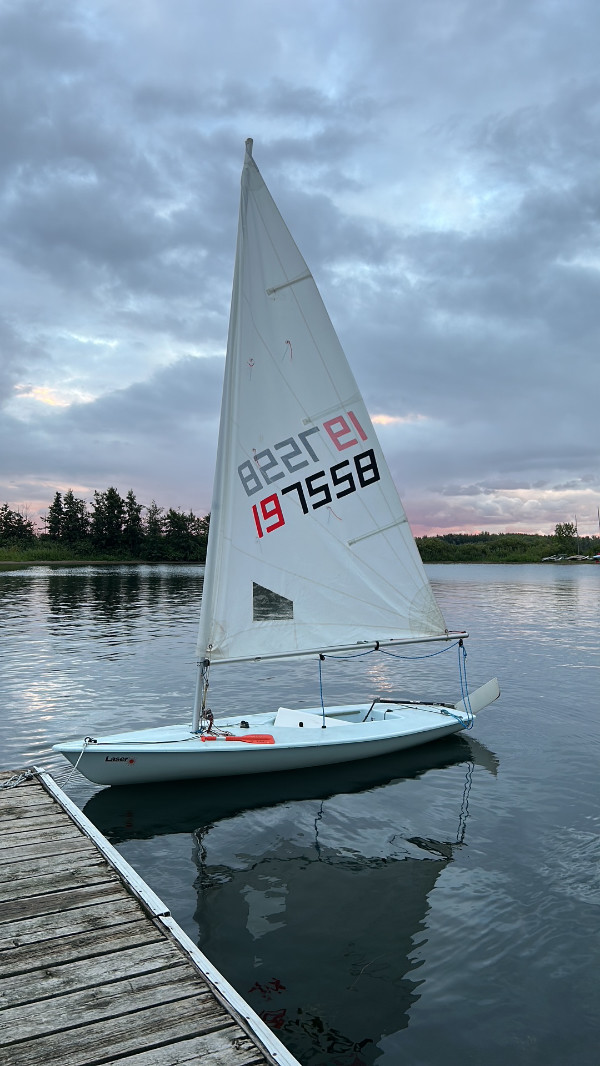 A very small, sharp-nosed sailboat, which
doesn't have anyone in it, but seems to be a one-person craft.