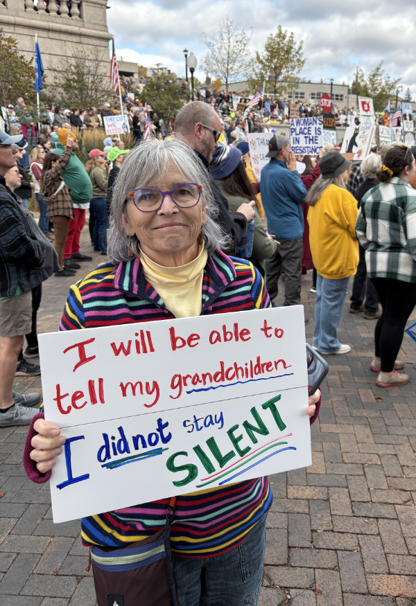 A woman holds a sign that
says 'I will be able to tell my grandchildren I did not stay SILENT