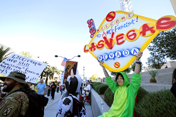 A person in a
dinosaur costume holds a sign that mimics the famous Googie 'Welcome to Las Vegas' sign, and says 'WELCOME TO
ANTI-Fascist LAS VEGAS NEVADA.