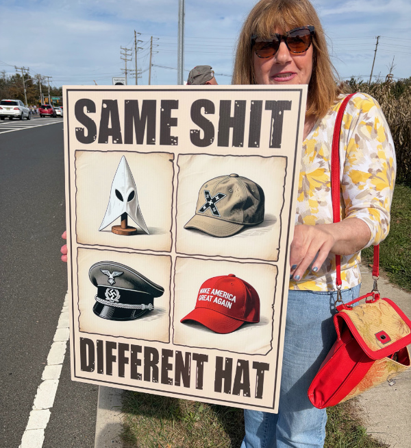 A woman holds a sign that shows
a Klan hood, a Nazi officer's dress hat, a white supremacist truckers' cap, and a MAGA hat, and that says 'SAME SHIT,
DIFFERENT HAT.