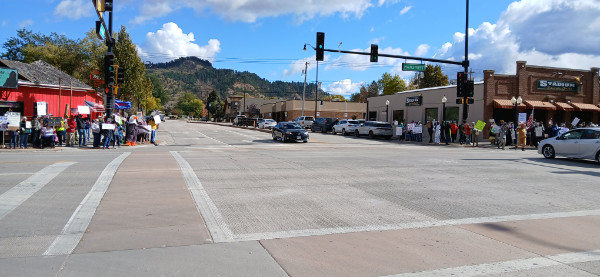 A good-sized crowd lines
two corners of a fairly rural intersection