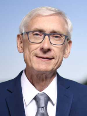 A headshot of Evers. He is a pleasant-looking but obviously elderly man with fashionable eyeglasses and white hair