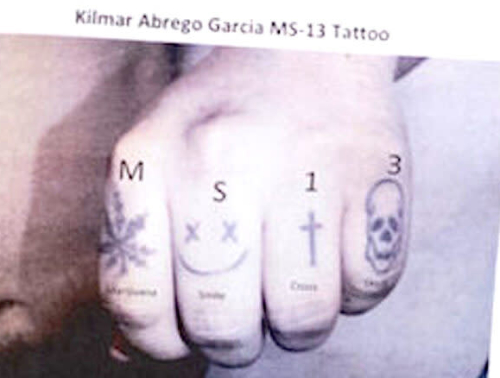 The four fingers of the fist
have a marijuana leaf, a smiley face with x's for the eyes, a cross, and a skull. Above those images is the phrase M S 1 3,
below them are the words 'marijuana,' 'smile,' 'cross' and 'skull'