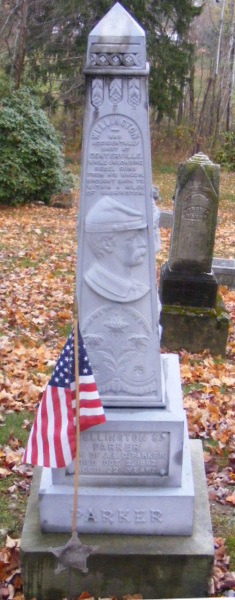 A tall obelisk-shaped
gravestone, with a relief of a man's face