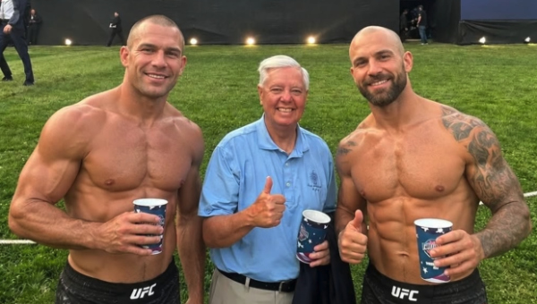 Graham is flanked by two
beefy, shirtless UFC fighters; all three are giving the thumbs up