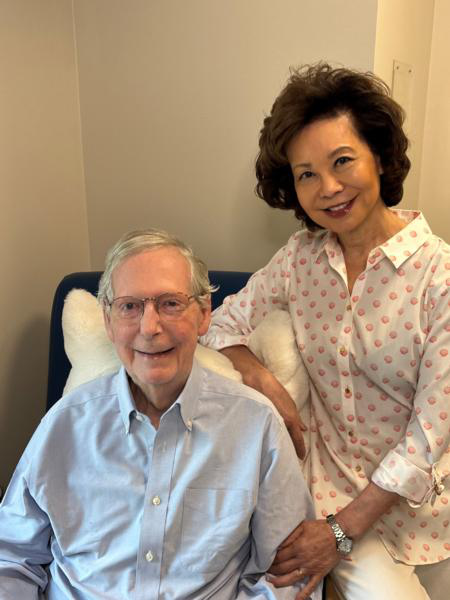 McConnell in what looks 
to be a white lounge chair, with Elaine Chao sitting on the armrest.