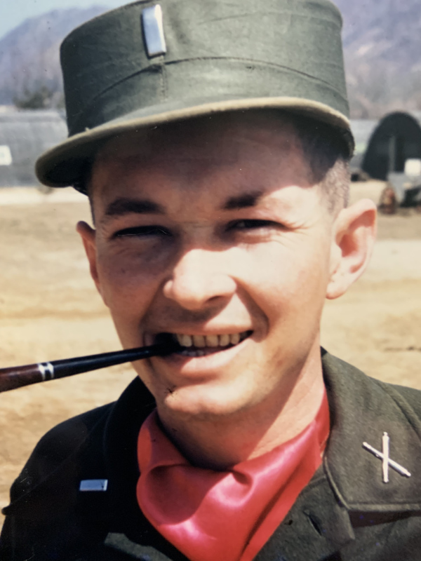 A gentleman
smoking a pipe and wearing a first lieutenant's silver bar along with a jaunty red scarf