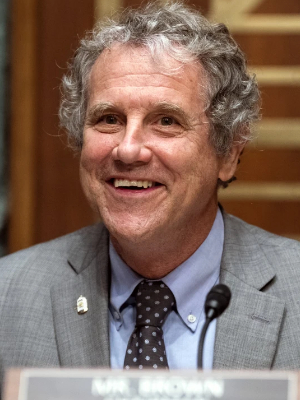 Brown at some sort of committee
meeting, with a smile and unruly curly gray hair