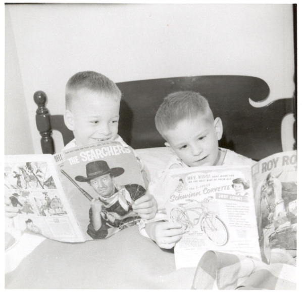 A black and white photo
of two kids, around 5 years old, reading 'The Searchers' and 'Roy Rogers'